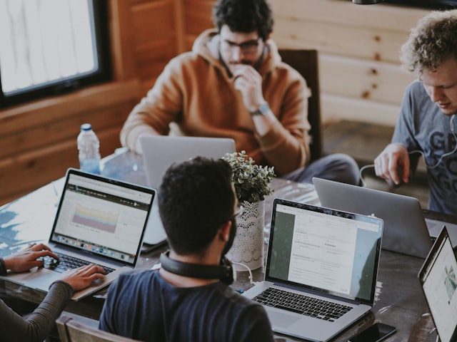 Startend ondernemersteam werkt samen met laptops